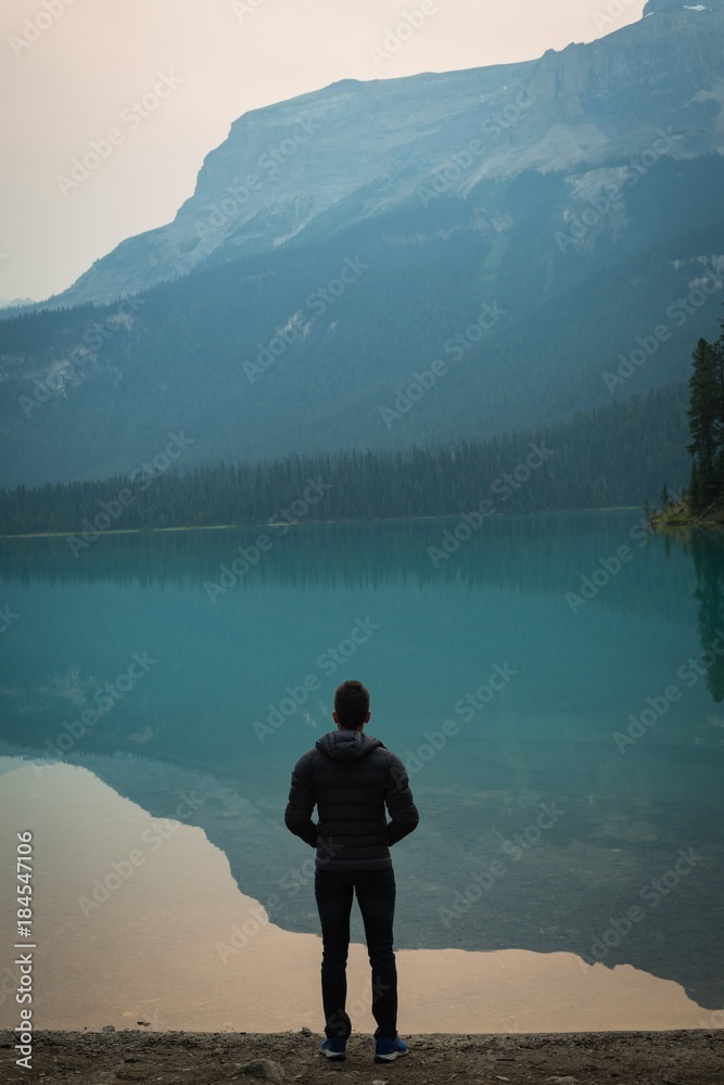 Rear view of man standing near the lake