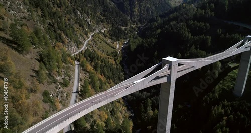 Truck on a bridge, Cinema 4k aerial view following a truck driving over a huge alpine bridge, between mountains, on a sunny fall day, on simplon pass, in wallis, of the alps in Switzerland