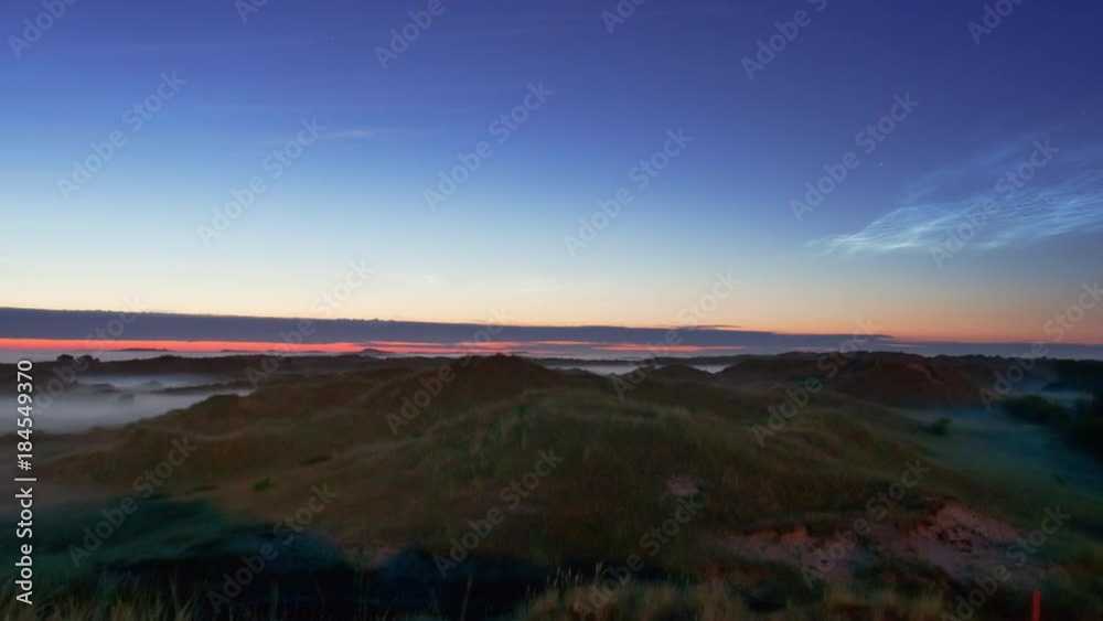 noctilucent clouds NLC with early morning fog over landscape island North Sea in summer twilight timelapse noctilucent clouds NLC with early morning fog over landscape island North Sea in summer twilight timelapse