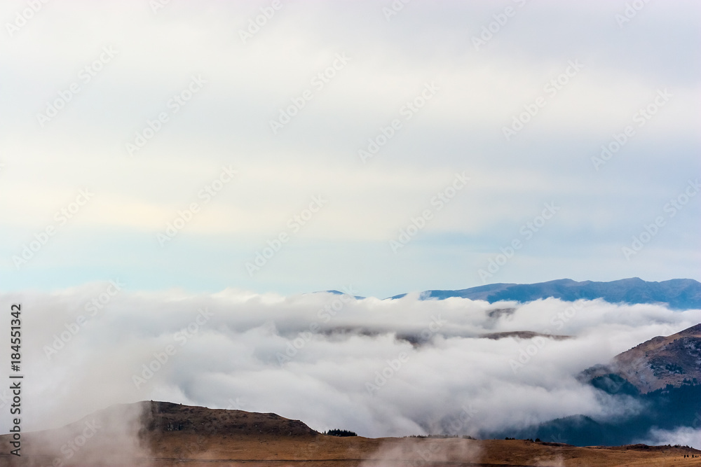 A dreamy mountain scene with clouds cover on a mountain hill A dreamy mountain scene with clouds cover on a mountain hill