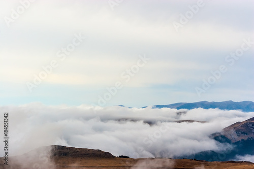 A dreamy mountain scene with clouds cover on a mountain hill