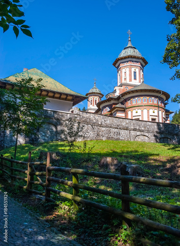 Sinaia orthodox church outside the monastery walls. Alley and wood fence in the foreground