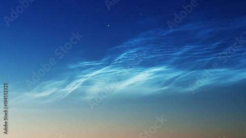 noctilucent clouds NLC with stars and filament gravity wave structure in summer morning twilight timelapse ZOOM IN photo