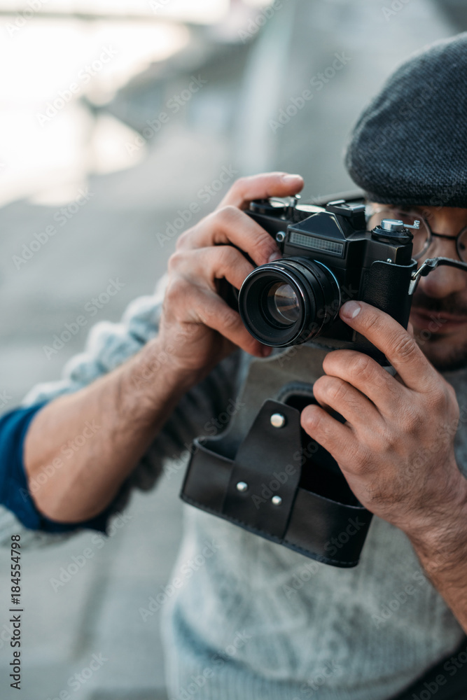 Obraz premium close-up shot of handsome adult man with vintage film camera outdoors