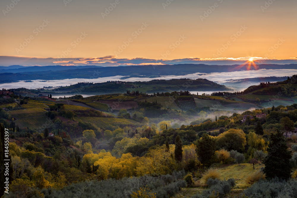Landscape with a morning fog and sunrise in the vicinity of the city of San Gimignano, Tuscany