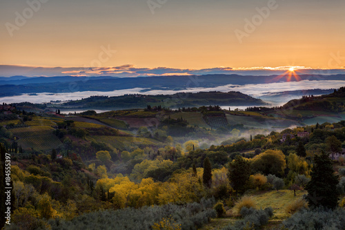 Landscape with a morning fog and sunrise in the vicinity of the city of San Gimignano, Tuscany