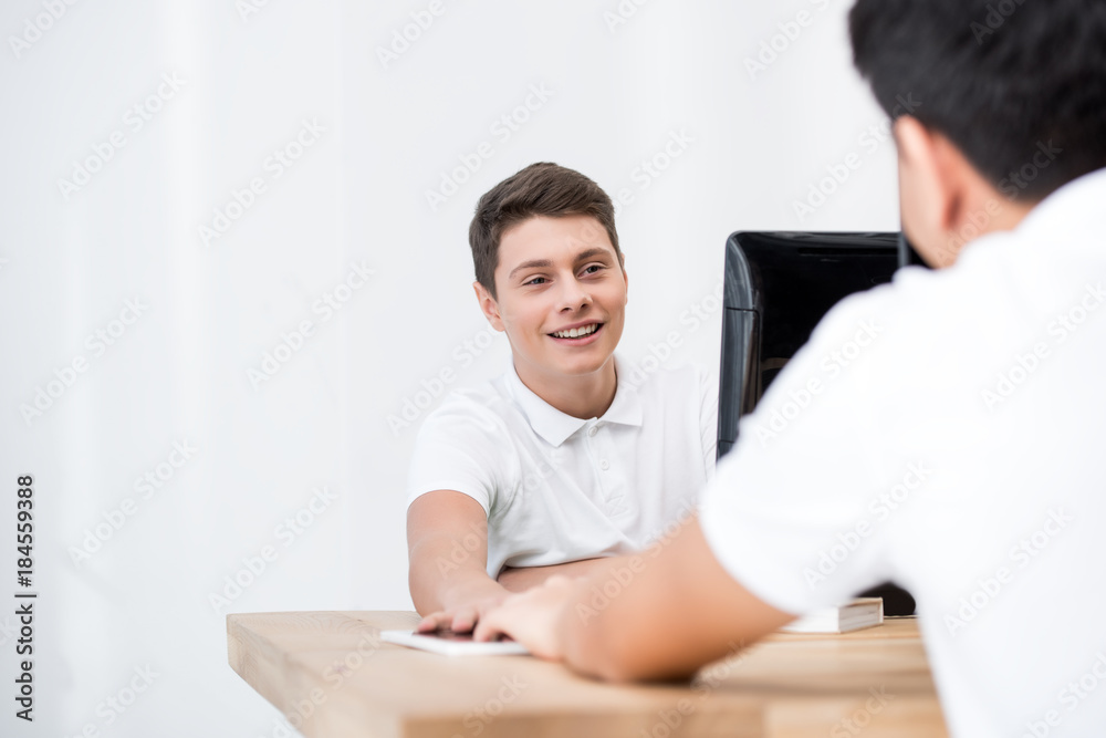 two teenager students sharing tablet and looking at each other two teenager students sharing tablet and looking at each other