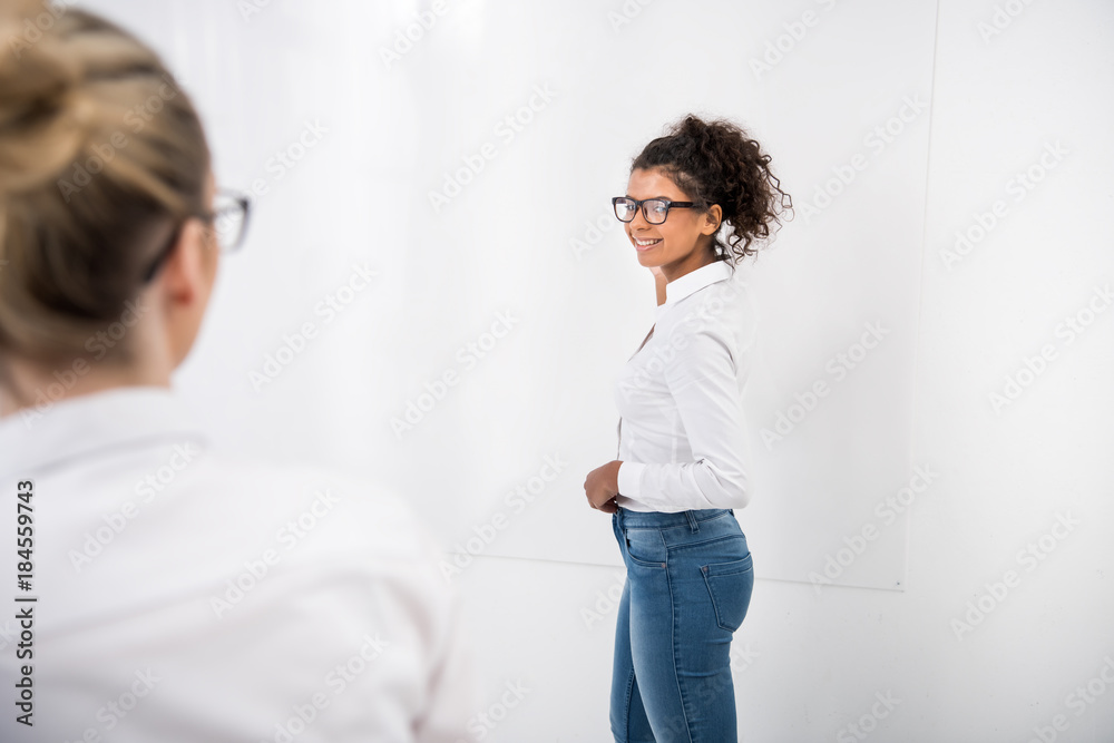 Fototapeta premium young african american teenager writing on white board