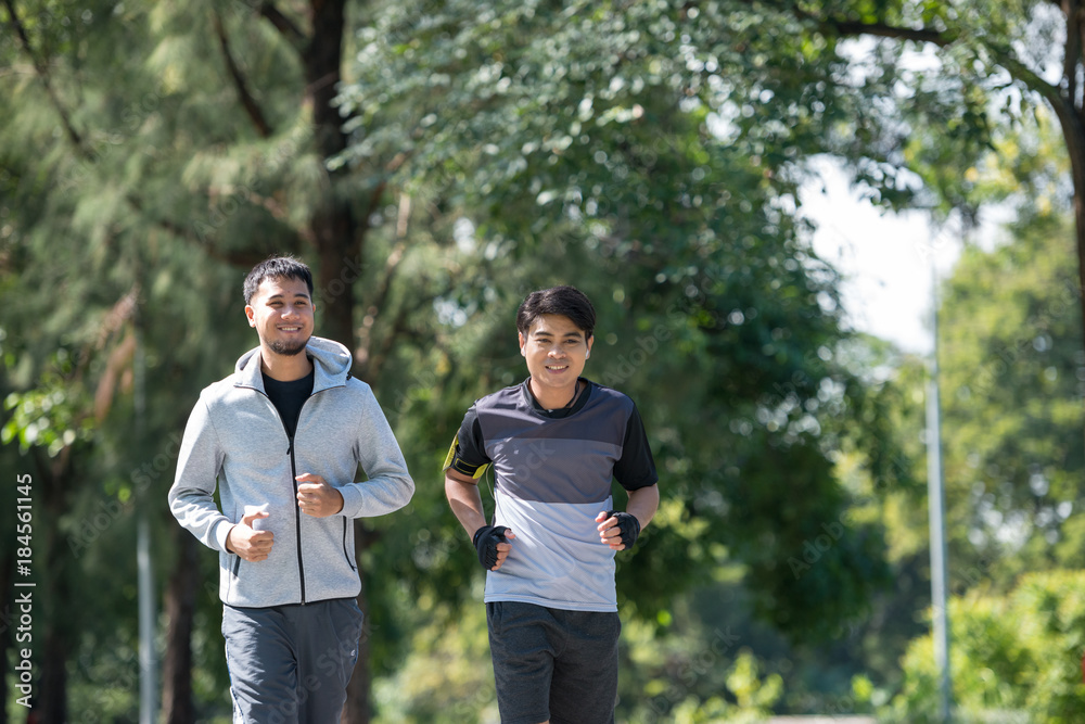 Two young fitness man running at morning in the garden, park Two young fitness man running at morning in the garden, park