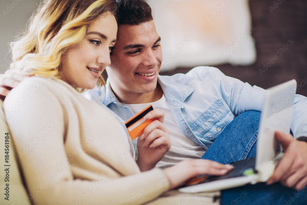 Young couple with laptop and credit card at home. Internet shopping concept Young couple with laptop and credit card at home. Internet shopping concept