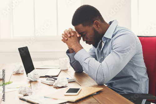 Overworking african-american employee at workplace
