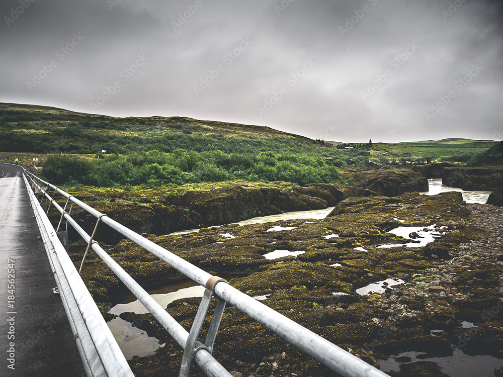 bridge over the river between green moss rocks in Iceland
