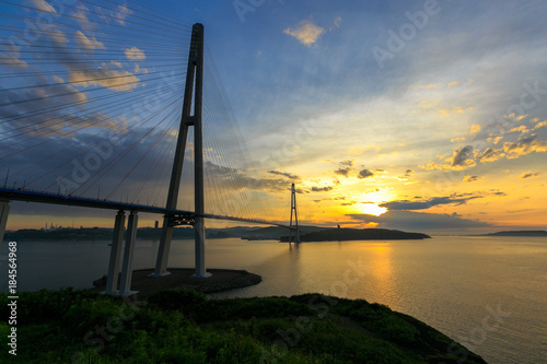 Fototapeta Naklejka Na Ścianę i Meble -  Amazing zooming out aerial view of the Russky Bridge, the world's longest cable-stayed bridge, and the Russky (Russian) Island in Peter the Great Gulf in the Sea of Japan. Sunrise. Vladivostok, Russia