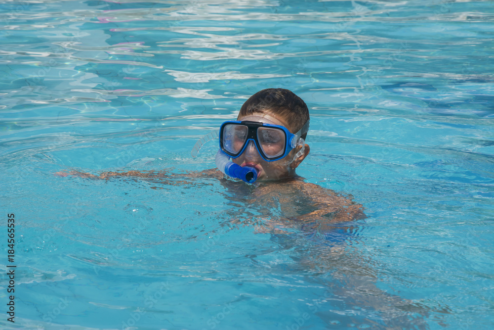 The little boy in the water with diving equipment