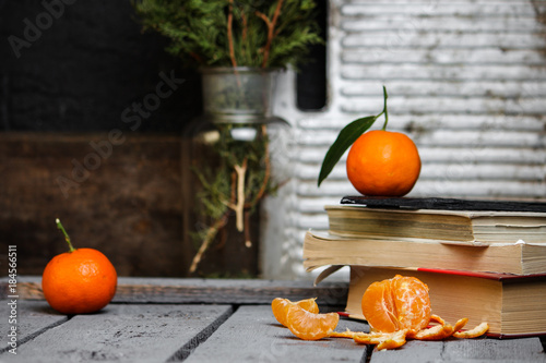 citrus fruit with green leaves and books on the table, reading