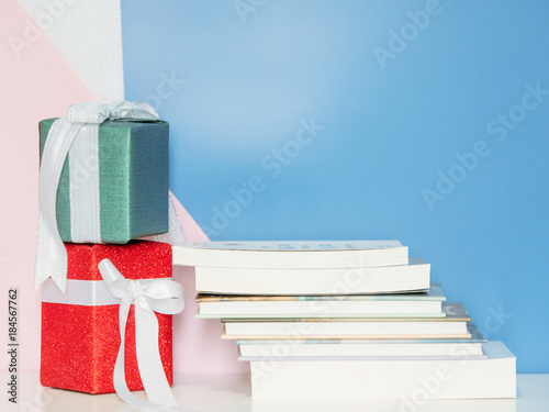 decoration set for christmas and new year event by wrapped gift box and set of book with blue and pink colour background