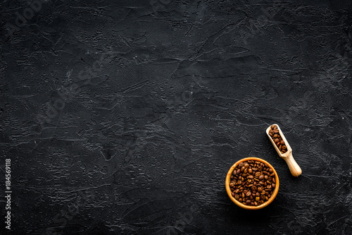 Coffee background. Roasted beans in bowl and scoop on black table top view