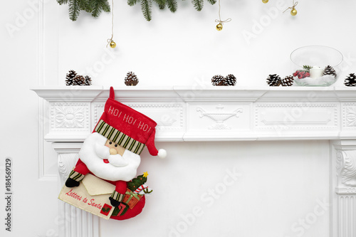 A close picture of beautifully decorated Santa Christmas socks with ho! ho! ho! word hanging on a fireplace waiting for presents. photo