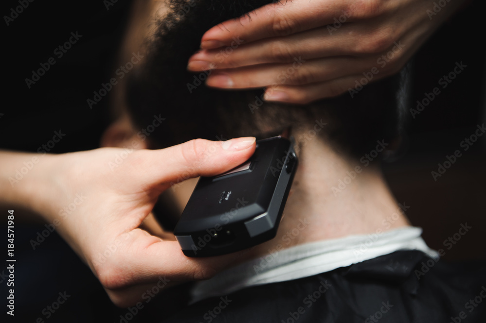 Master cuts hair and beard of men in the barbershop, hairdresser makes hairstyle for a young man Master cuts hair and beard of men in the barbershop, hairdresser makes hairstyle for a young man