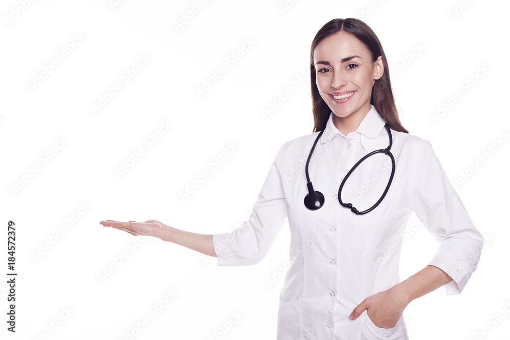 Smiling attractive modern doctor with stethoscope isolated on white background and pointing on copyspace Smiling attractive modern doctor with stethoscope isolated on white background and pointing on copyspace