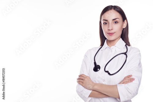 Modern Woman doctor with stethoscope and crossed hands looking into the camera isolated on white background with copyspace.