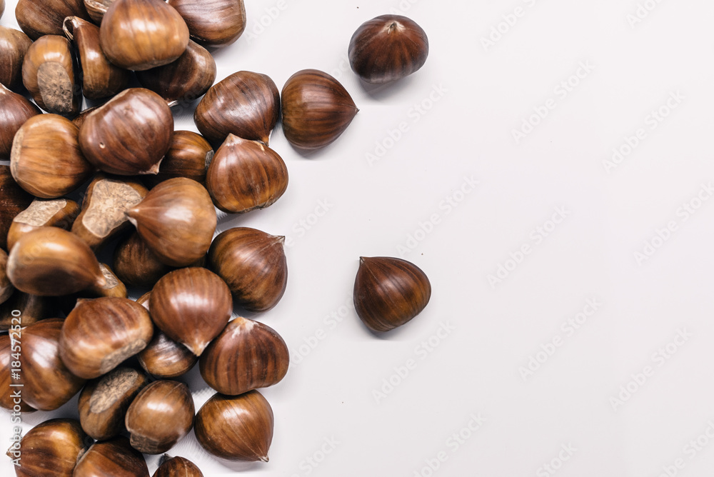 Chestnuts on a blank (white) background. Chestnuts arranged on left side with copy space. Chestnuts on a blank (white) background. Chestnuts arranged on left side with copy space.