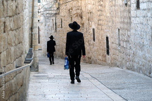 Two unrecognized religious jewish men walking down the street in Old City of Jerusalem.