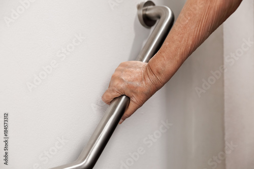 Canvas Print Elderly woman holding on handrail for safety walk steps