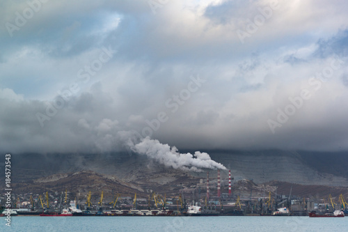 The bleak industrial landscape covered with smog of the city and cloudy sky