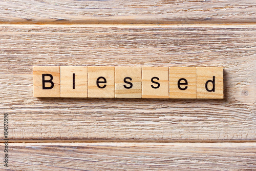 Blessed word written on wood block. Blessed text on table, concept