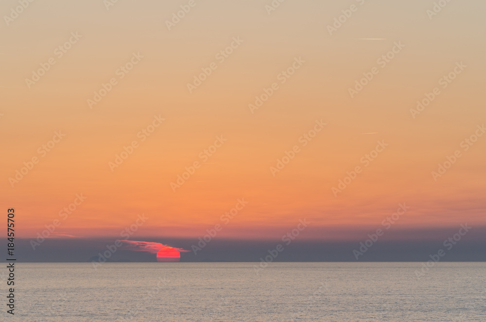 rote sonne im meer am horizont