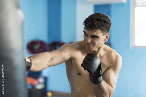 Boxer in gym training with punching bag