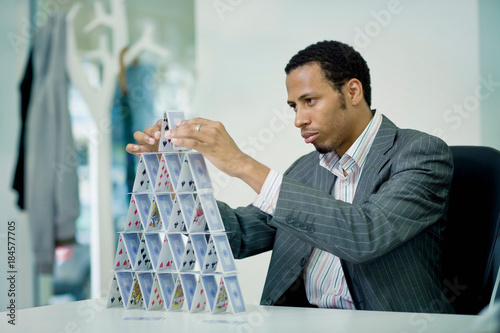 Businessman building house of cards