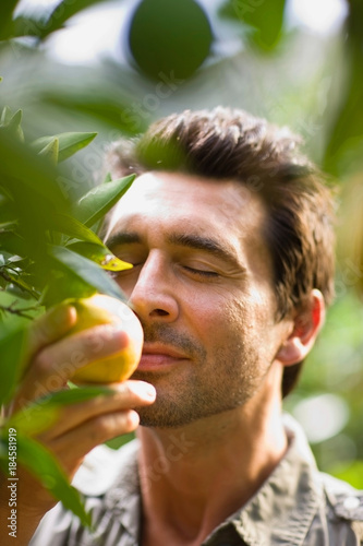 Man smelling at orange photo