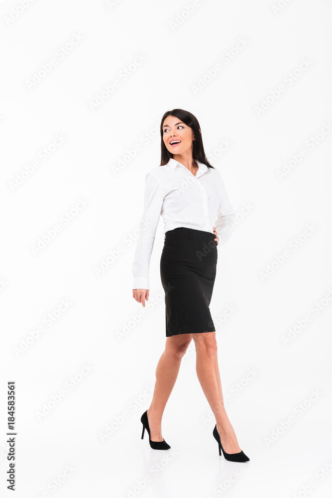 Full length portrait of a smiling asian businesswoman walking Full length portrait of a smiling asian businesswoman walking