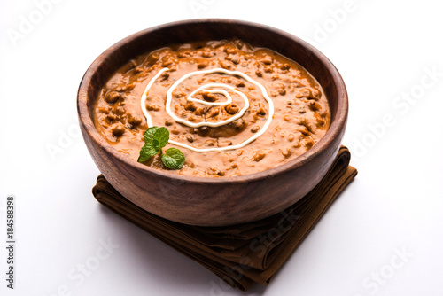 Dal makhani or dal makhni is a popular food from Punjab / India made using  whole black lentil, red kidney beans, butter and cream and served with garlic naan or Indian bread or roti

