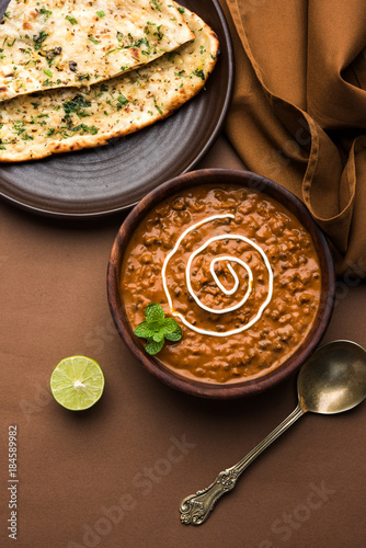Dal makhani or dal makhni is a popular food from Punjab / India made using  whole black lentil, red kidney beans, butter and cream and served with garlic naan or Indian bread or roti

