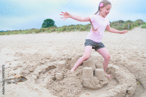 Photography Girl destroying sand castle on beach