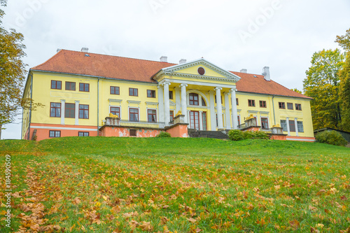 Old yellow manor house with orange roof at Latvia. photo