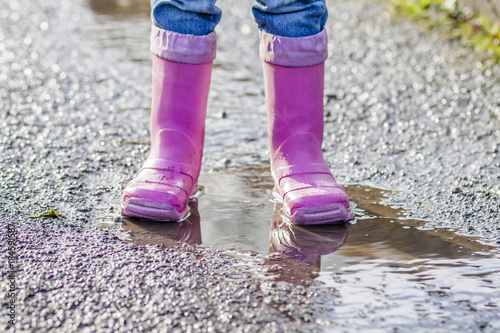 Little girl with pink wellys in the puddle photo