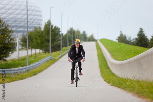 Businessman riding bicycle in urban park