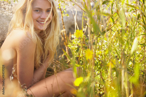 Young woman nude in long grass