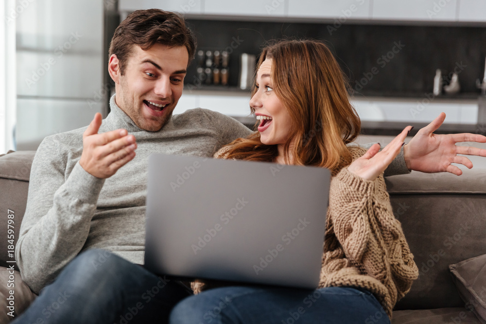 Excited cheerful loving coupe using laptop computer. Excited cheerful loving coupe using laptop computer.