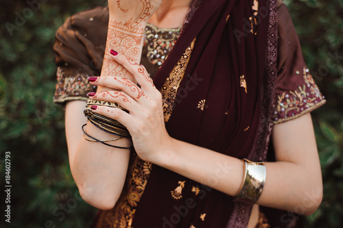 Woman Hands with black mehndi tattoo. Hands of Indian bride girl with black henna tattoos. Fashion. India