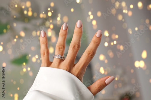 Diamond ring on a finger.