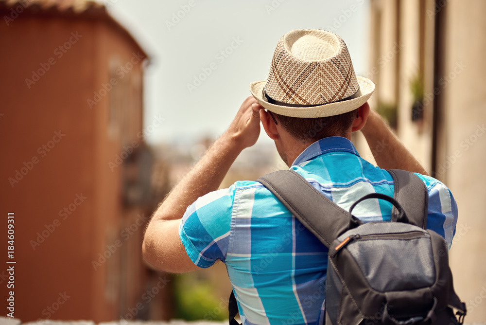 Traveler in sunhat is enjoying a town streets view.