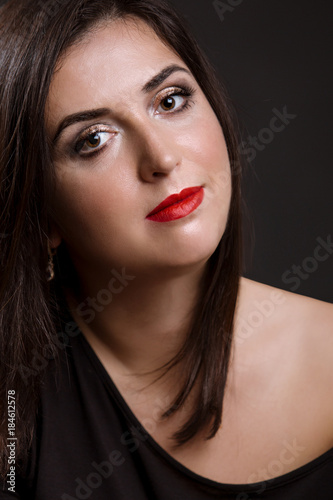Portrait of a beautiful young smiling woman on a dark background