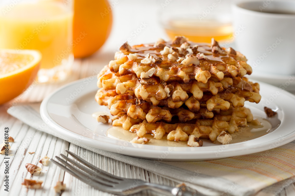 Belgian waffles with honey and walnuts on white wooden background. Belgian waffles with honey and walnuts on white wooden background.