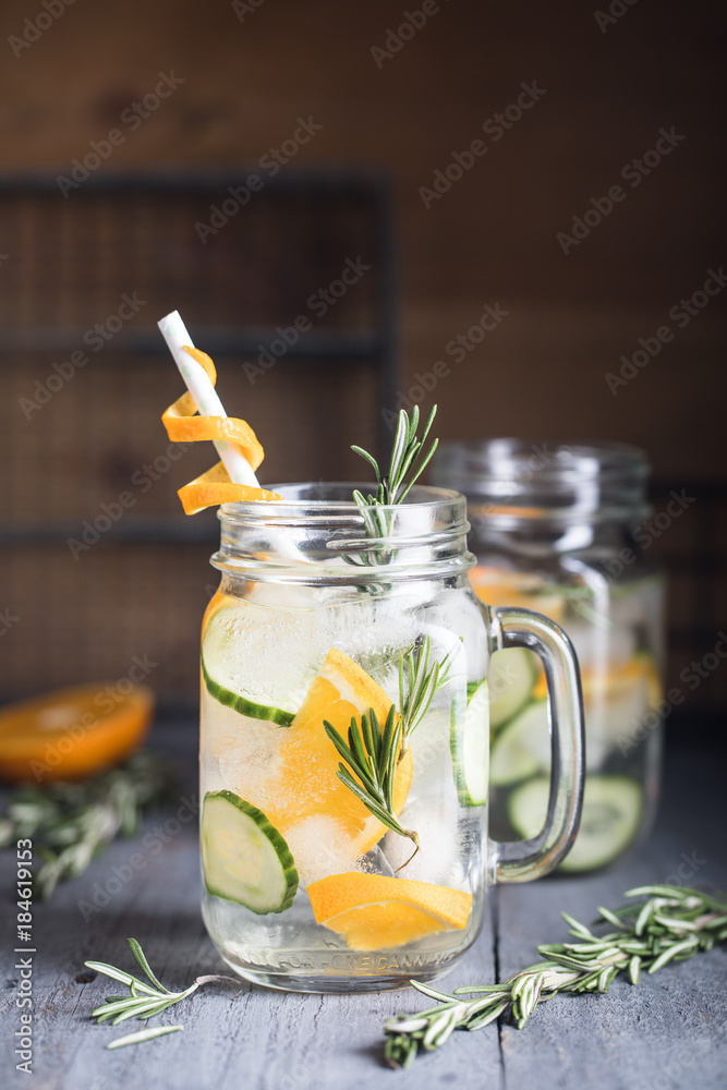 Homemade orange lemonade with cucumber and rosemary on the dark rustic background Homemade orange lemonade with cucumber and rosemary on the dark rustic background