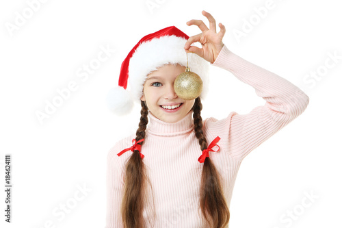 Young girl in santa hat with bauble on white background